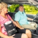 Woman using a portable oxygen concentrator in a carry bag while riding in a car